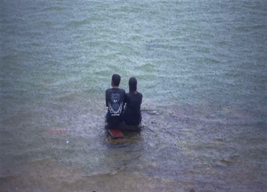 A Shot of Couple Enjoying Monsoon Rain by the Lakeside