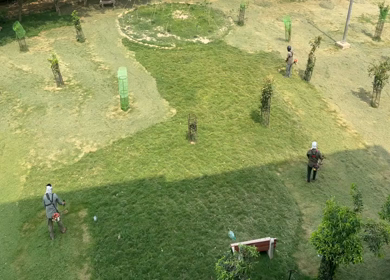 A Shot of Ground workers cutting grass with brush cutter machine in park