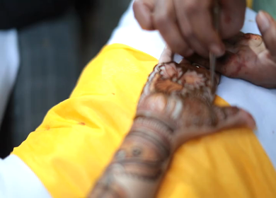 A Slow Motion Shot of Mehndi being applied on a girls hand at an Indian Wedding in India