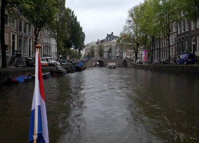 Slow Motion Shot of Amsterdam Canal Water with Dutch Flag in Amsterdam