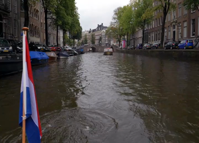 Slow Motion Shot of Amsterdam Canal Water with Dutch Flag in Amsterdam