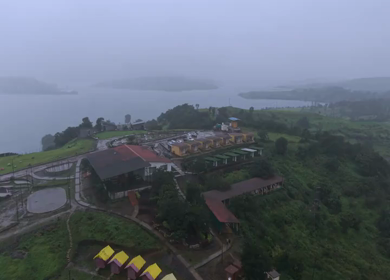 Aerial Drone View of Bhandardara Landscape with Green Valley River and Monsoon Clouds Maharashtra India