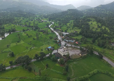 Aerial Drone View of Bhandardara Landscape with Green Valley River and Monsoon Clouds Maharashtra India