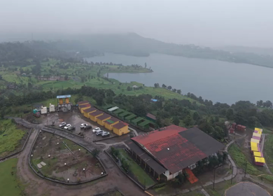 Aerial Drone View of Bhandardara Landscape with Green Valley River and Monsoon Clouds Maharashtra India