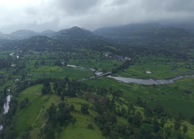 Aerial Drone View of Bhandardara Landscape with Green Valley River and Monsoon Clouds Maharashtra India