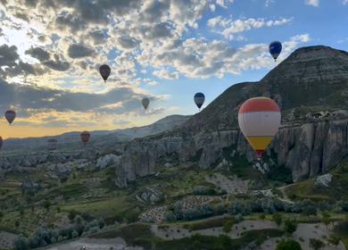 Aerial View of Hot Air Balloons Flying Over Cappadocia Landscape in Turkey