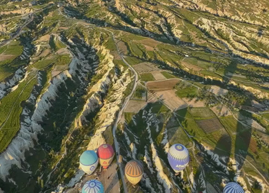 Aerial View of Hot Air Balloons Flying Over Cappadocia Landscape in Turkey
