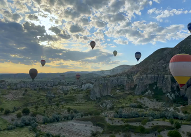 Aerial View of Hot Air Balloons Flying Over Cappadocia Landscape in Turkey