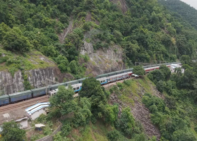 Aerial View of Indian Railways Freight Train Emerging from Tunnel Through Forested Hills, Andhra Pradesh