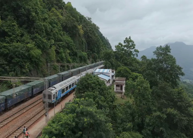 Aerial View of Indian Railways Freight Train Emerging from Tunnel Through Forested Hills, Andhra Pradesh