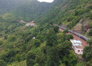 Aerial View of Indian Railways Freight Train Emerging from Tunnel Through Forested Hills, Andhra Pradesh