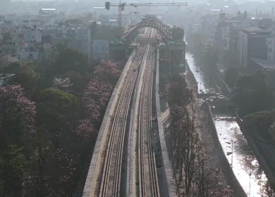 Aerial View of Metro Line and Road at Silk Board Junction with Pink Blossom Trees Bengaluru