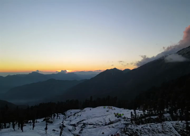 Aerial View of Sunset Over Brahmatal Mountains with Snow Camps Uttarakhand Himalayas India