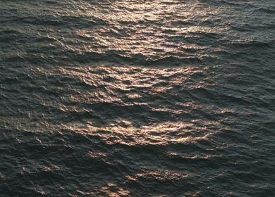 Aerial View of Sunset Over Ocean Horizon with Golden Light and Clouds in Kerala