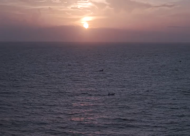 Aerial View of Sunset Over Ocean Horizon with Golden Light and Clouds in Kerala