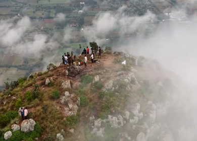 Aerial View of Tourists Standing on Kondarangi Hills Peak in Misty Clouds Tamil Nadu