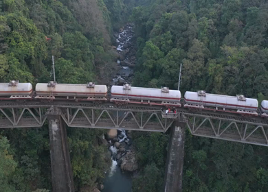 Aerial View of Train Crossing Bridge Over Forest River Yedekumari Karnataka India
