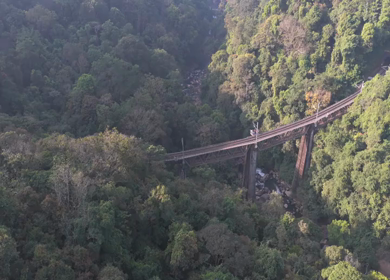 Aerial View of Train Crossing Bridge Over Forest River Yedekumari Karnataka India