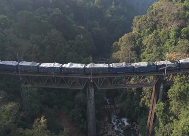Aerial View of Train Crossing Bridge Over Forest River Yedekumari Karnataka India