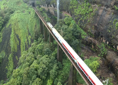 Aerial View of Train Crossing Waterfalls on Mountain Railway Bridge in Lonavala Maharashtra