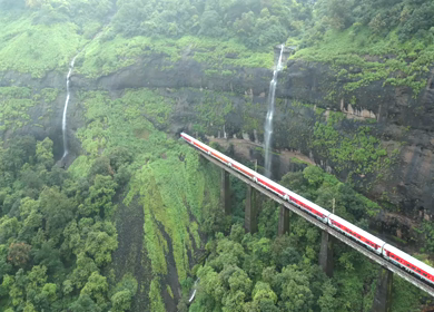 Aerial View of Train Crossing Waterfalls on Mountain Railway Bridge in Lonavala Maharashtra