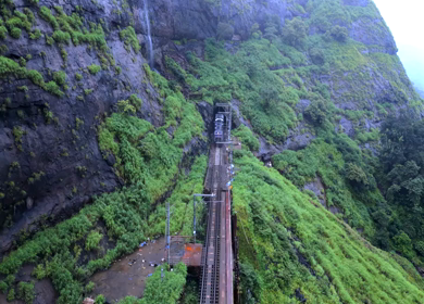 Aerial View of Train Crossing Waterfalls on Mountain Railway Bridge in Lonavala Maharashtra