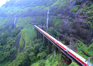Aerial View of Train Crossing Waterfalls on Mountain Railway Bridge in Lonavala Maharashtra