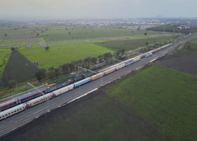 Aerial View of Train Passing Through Agricultural Fields in Tumkur India