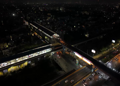 Aerial night view of Delhi Metro train and illuminated station in New Delhi India