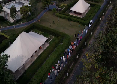 Aerial shot of a traditional Indian wedding baraat procession with dancing guests and festive lights
