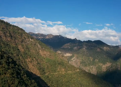 Aerial timelapse of forested mountains and rolling hills under moving clouds in Uttarakhand, India