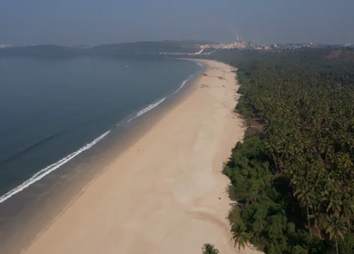 Aerial view of sandy beach with turquoise sea and palm trees in Phuket, Thailand