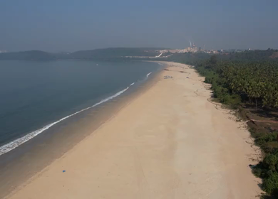 Aerial view of sandy beach with turquoise sea and palm trees in Phuket, Thailand