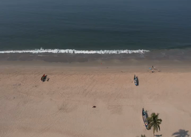 Aerial view of sandy beach with turquoise sea and palm trees in Phuket, Thailand
