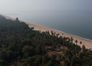 Aerial view of sandy beach with turquoise sea and palm trees in Phuket, Thailand
