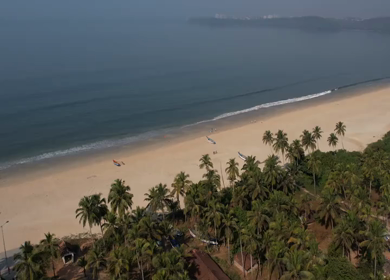 Aerial view of sandy beach with turquoise sea and palm trees in Phuket, Thailand