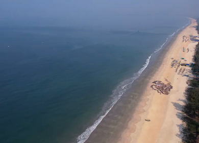 Aerial view of sandy beach with turquoise sea and palm trees in Phuket, Thailand