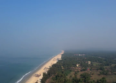 Aerial view of sandy beach with turquoise sea and palm trees in Phuket, Thailand