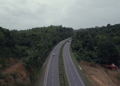 Aerial view of car driving through dense forest road in Karnataka India