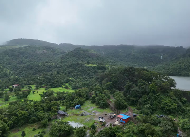 Aerial drone view of lush green hills and reservoir in Maharashtra India