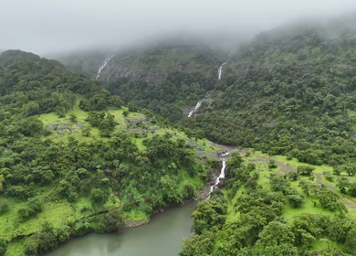 Aerial drone view of lush green hills and reservoir in Maharashtra India
