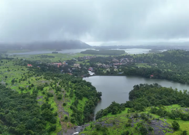 Aerial drone view of lush green hills and reservoir in Maharashtra India
