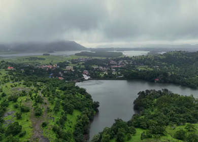 Aerial drone view of lush green hills and reservoir in Maharashtra India