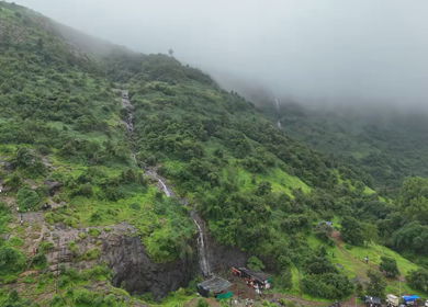 Aerial drone view of lush green hills and reservoir in Maharashtra India