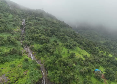 Aerial drone view of lush green hills and reservoir in Maharashtra India