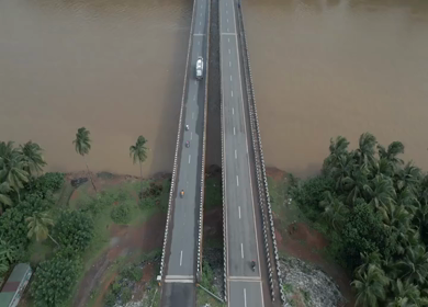 Aerial view of river and road bridge,Gangavali Bridge surrounded by coconut trees in Gokarna Karnataka India