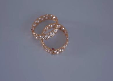 A slow motion shot of elegant Indian bridal jewelry featuring an ornate necklace, bangles, earrings, and headpiece