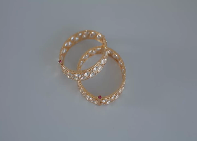 A slow motion shot of elegant Indian bridal jewelry featuring an ornate necklace, bangles, earrings, and headpiece