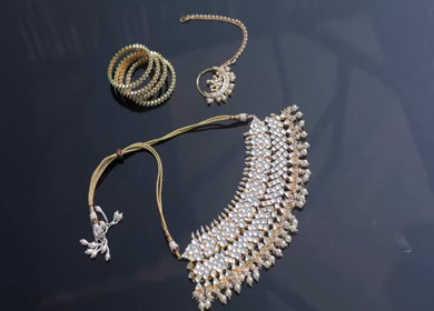 A slow motion shot of elegant Indian bridal jewelry featuring an ornate necklace, bangles, earrings, and headpiece