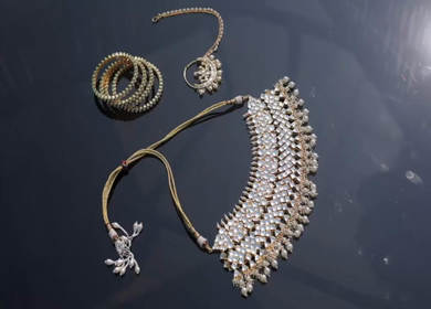 A slow motion shot of elegant Indian bridal jewelry featuring an ornate necklace, bangles, earrings, and headpiece
